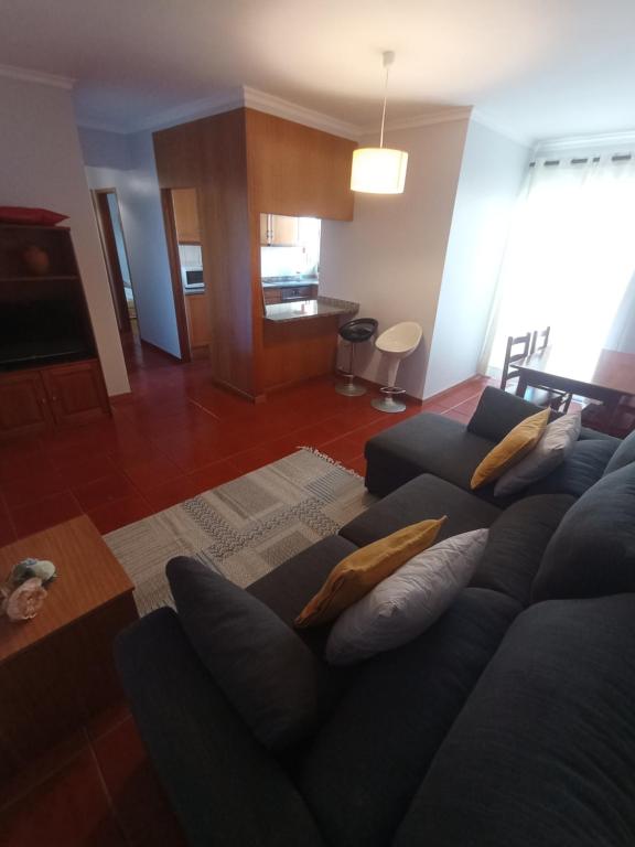 sala de estar con sofá azul y almohadas en Village Sea House - Porto Moniz, en Porto Moniz