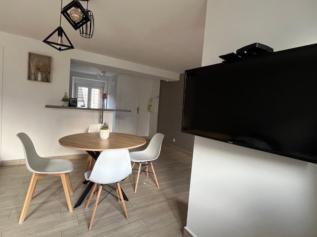 BuhlにあるCharmant appartement au cœur de Buhlのダイニングルーム(テーブル、椅子、薄型テレビ付)