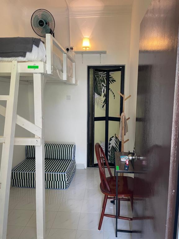 a room with bunk beds and a desk and a chair at Villa Mommy Bangi Pitstop Rooms in Bandar Baru Bangi