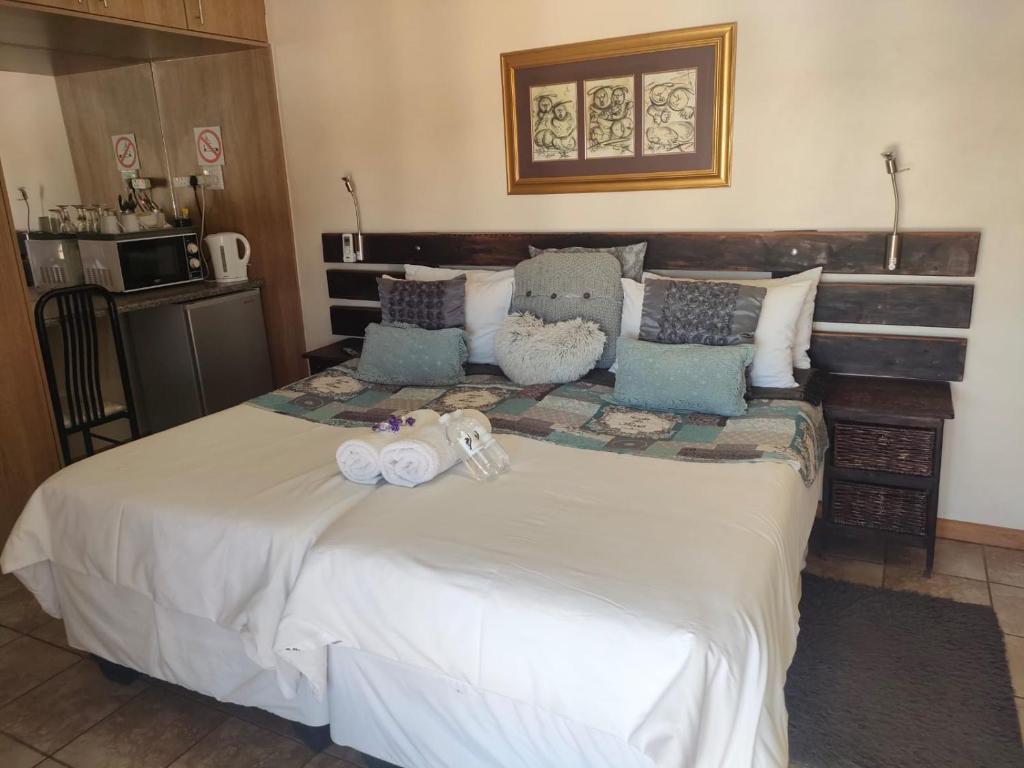 ein Bett mit zwei ausgestopften Tieren, die darauf sitzen in der Unterkunft Leopard Tree Guesthouse in Springbok