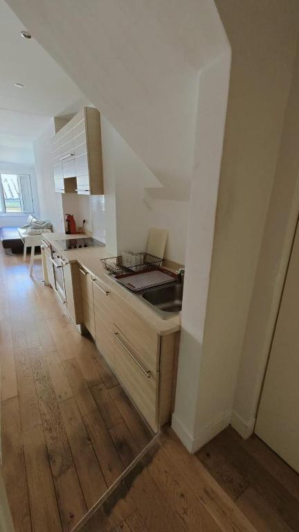 une cuisine avec des armoires blanches et un plancher en bois dans l'établissement Beach Proximity in Historic Nice, Your Perfect 2 Room Rental, à Nice