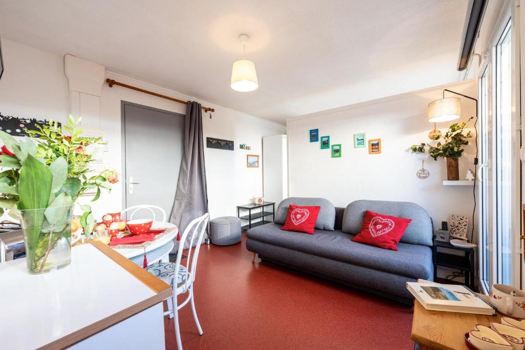 ein Wohnzimmer mit Sofa und Tisch in der Unterkunft Le Ptit Bois - Piscine partagée in Saint-Laurent-en-Grandvaux