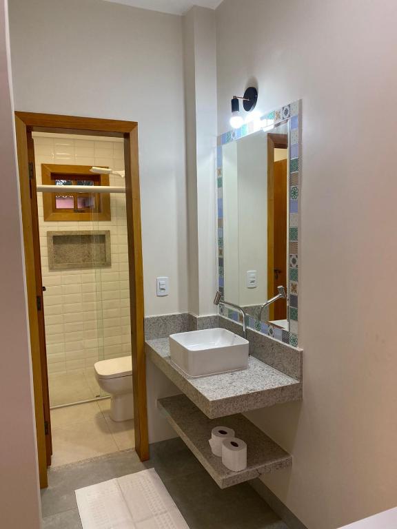 a bathroom with a sink and a toilet at Pousada Mãe Natureza in Pirenópolis
