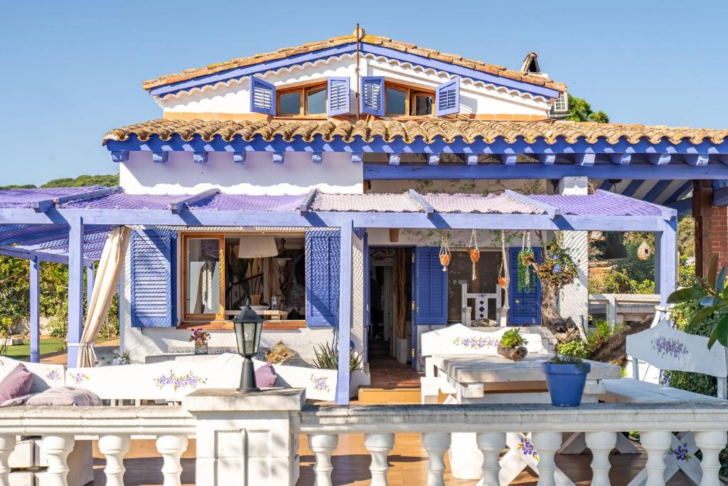 a blue house with a porch with white furniture at ツ Villa Carrasca l Luxe l Vista al Mar l Piscina Climatizada l Nature in Arenys de Munt