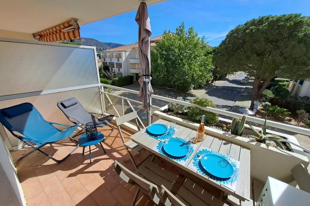 un balcon avec une table, des chaises et un parasol dans l'établissement Charming T2 - close to the 