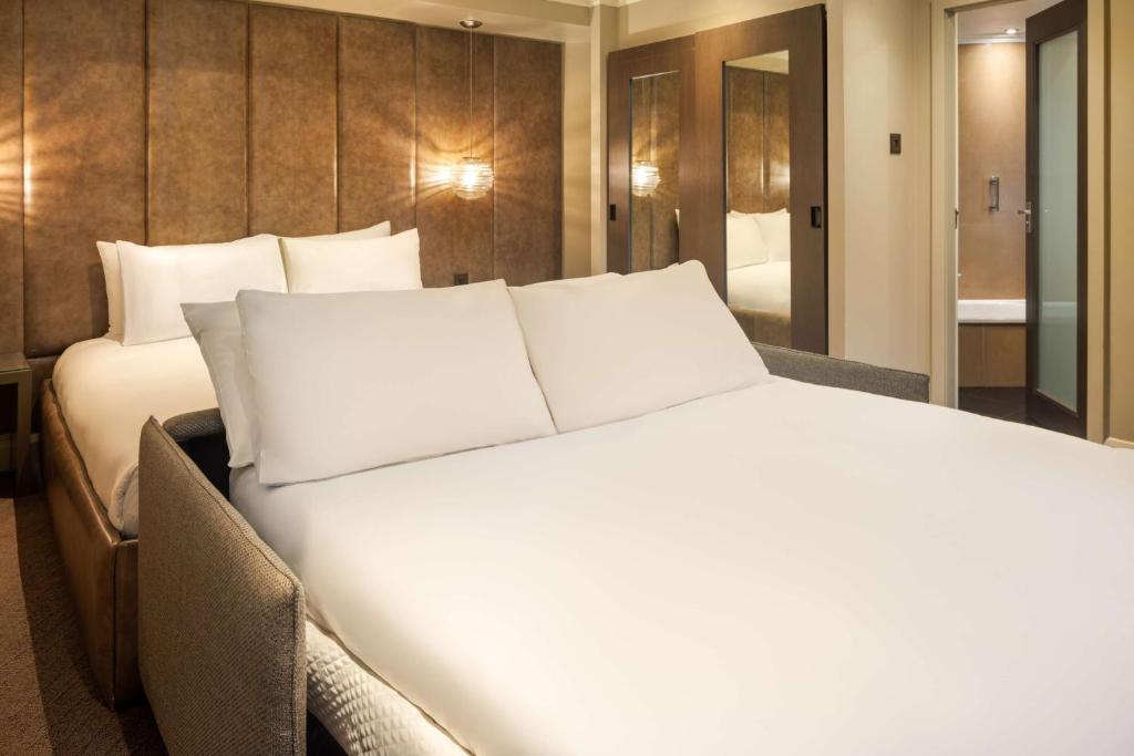 a large white bed in a hotel room at Radisson Blu Hotel, London Bloomsbury in London