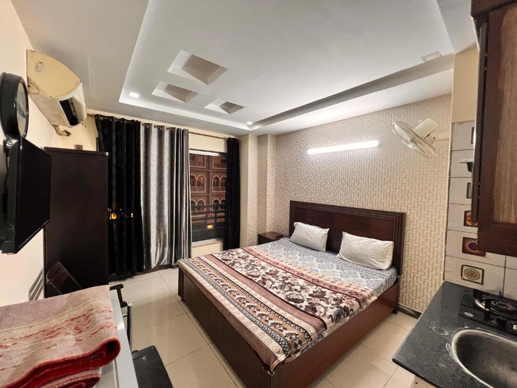 ラーワルピンディーにあるCrescent Cozy Apartmentのベッドと洗面台のある小さな寝室