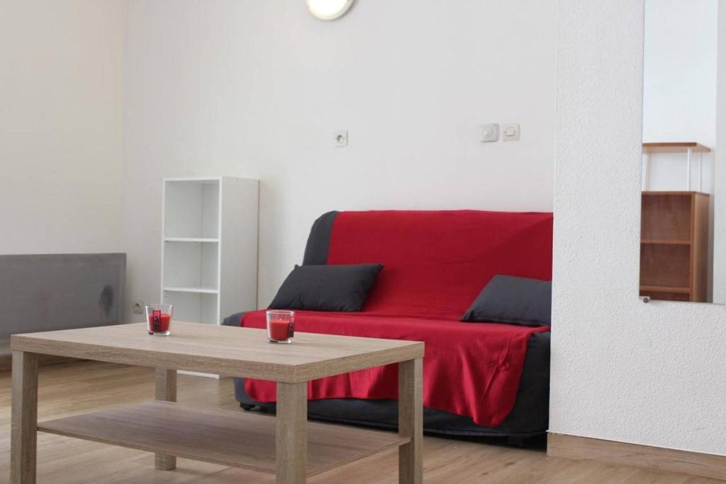 ラ・ロシェルにあるAppt 2 pièces LA ROCHELLE - LR030-C123の赤いソファとテーブルのあるリビングルーム