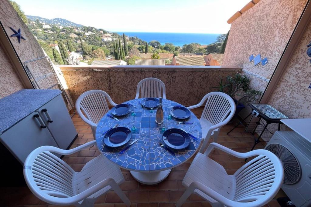 une table et des chaises sur un balcon avec vue dans l'établissement Duplex in Pramousquier - sea view, au Lavandou