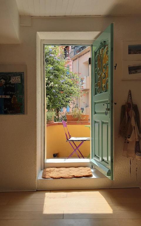 Une porte ouverte s'ouvre sur une terrasse avec une chaise. dans l'établissement Jetez l'ancre dans notre maison de pêcheur !, à Collioure