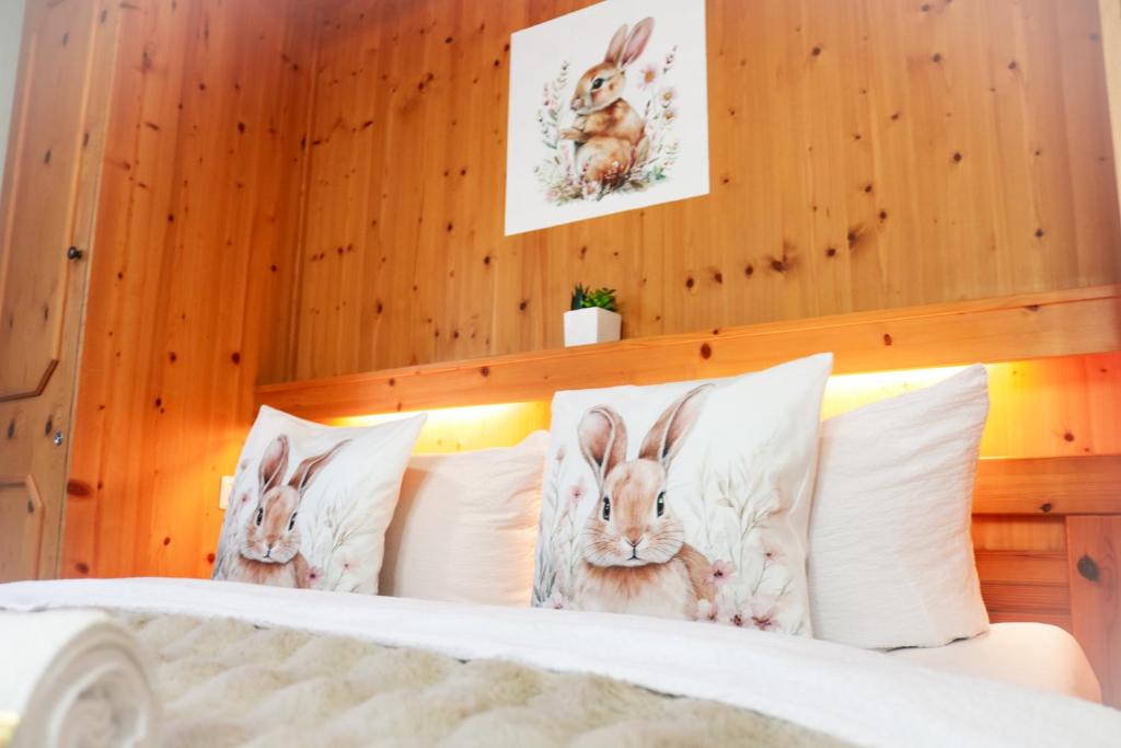 een slaapkamer met een bed met drie konijnen op de kussens bij House of Happiness by apartmentglück in Schluchsee