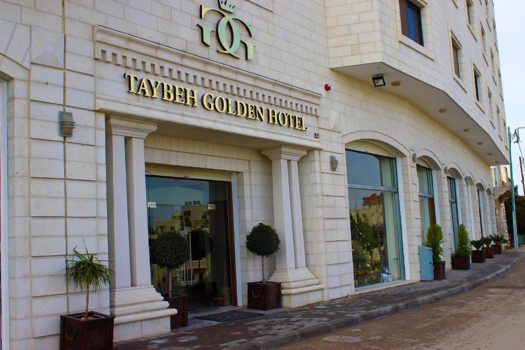 a building with a sign on the front of it at Taybeh Golden Hotel in Ramallah