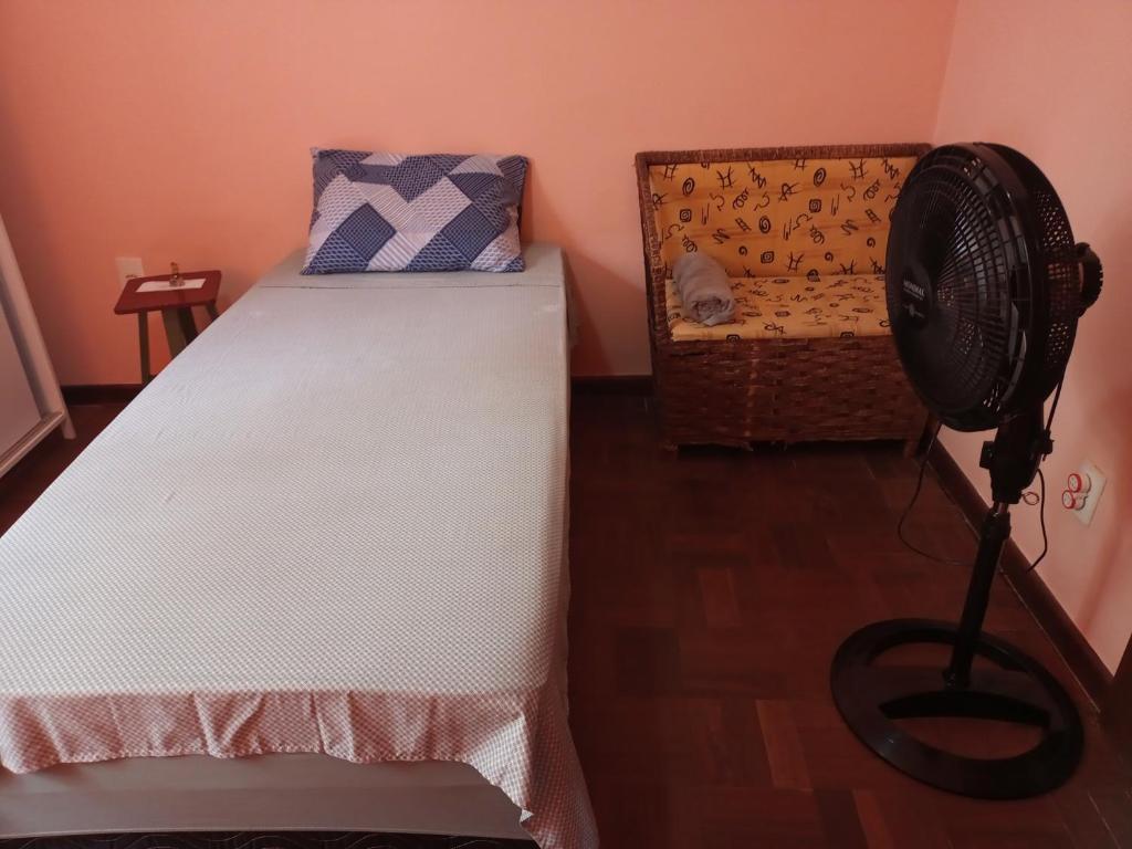 ein kleines Schlafzimmer mit einem Bett und einem Ventilator in der Unterkunft Alojamento do João in Lagoa Santa