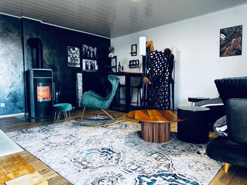 a living room with a table and chairs and a fireplace at Ferienwohnung Bavaria Weekend in Marktoberdorf