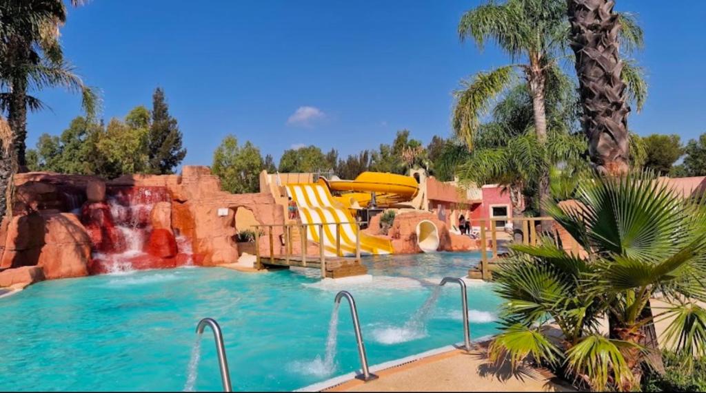 une piscine avec toboggan et un parc aquatique dans l'établissement Mobil-home neuf 6 à 8 pers au Camping Les Palmiers, Hyères, à Hyères