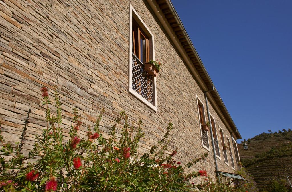 un edificio di mattoni con una finestra con un vaso di fiori di Hotel Rural da Quinta do Silval a Pinhão