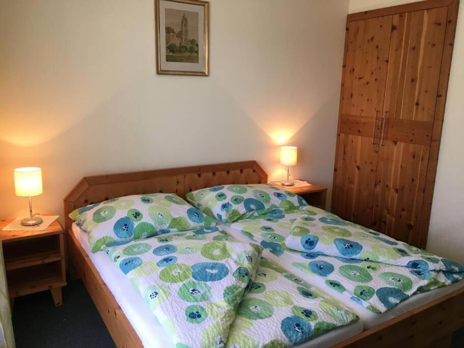 un letto in una camera da letto con due lampade sui tavoli di Appartements Caroline a Ossiach