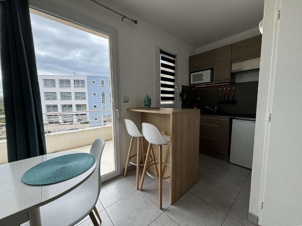 une cuisine avec une table et des chaises et une fenêtre dans l'établissement Appt 2 pièces LA ROCHELLE LR030-B226, à La Rochelle