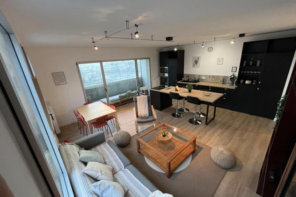 un salon et une cuisine avec un canapé et une table dans l'établissement 3-bedroom apartment with spacious balcony, à Nantes