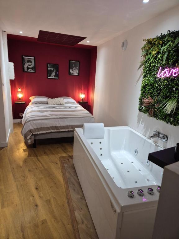 a bedroom with a bed and a bath tub next to a bed sidx sidx sidx at Love room les étoiles du désir in Périgueux
