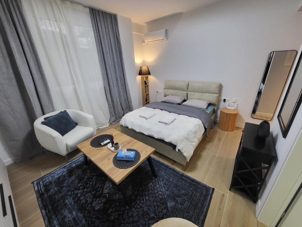 a bedroom with a bed and a table and a chair at Kolonaki Studio in Athens