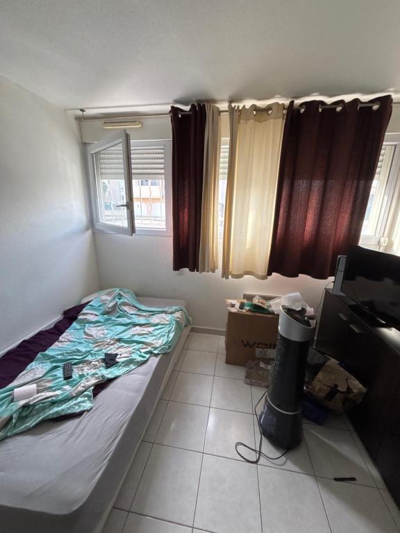 - une petite chambre avec un lit et du carrelage dans l'établissement Appartement cosy 2 pièce, à Perpignan