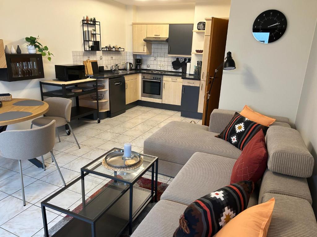 a living room with a couch and a kitchen at Modernes ruhiges Apartment in Scheidt, Uni-Nähe in Saarbrücken