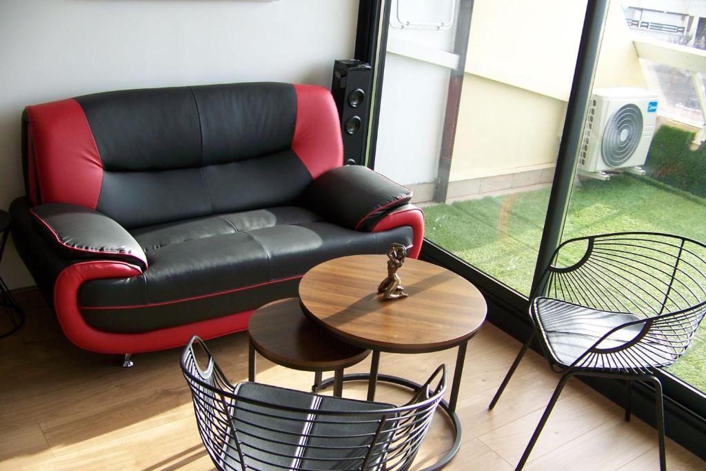 un salon avec un canapé, une table et des chaises dans l'établissement Naturiste Cap d'Agde Héliopolis E 100, au Cap d'Agde