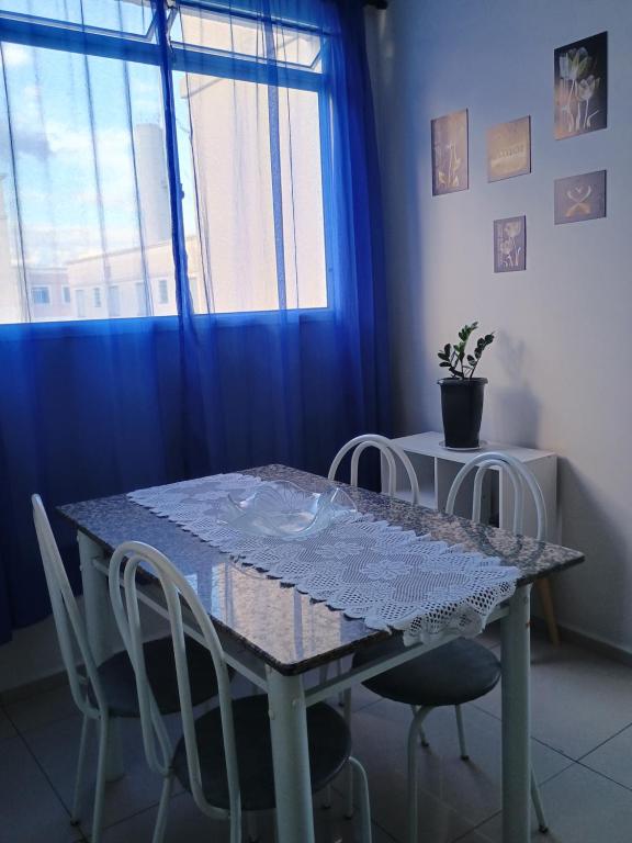ピンダモニャンガバにあるNosso apêのダイニングルーム(椅子、青いカーテン付)