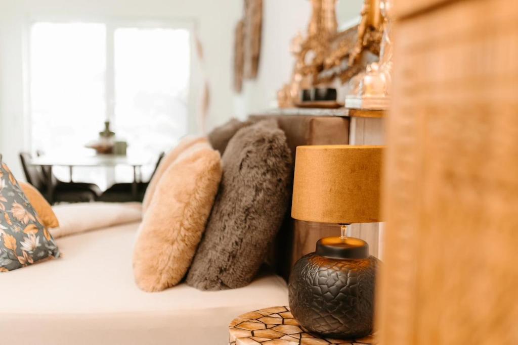 a couch with pillows and a lamp on a table at Waldzauber Appartement in Horhausen