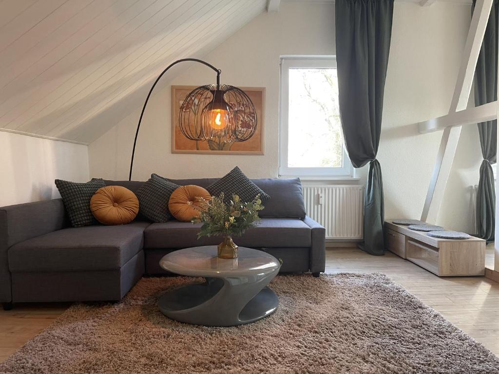 a living room with a couch and a table at Gemütliches Mansarden-Apartment mit 2 Schlafzimmern & separater Küche in Herne