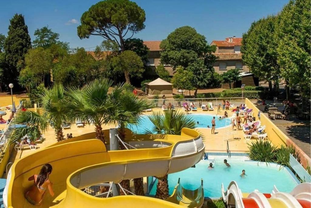 - une piscine dans un complexe avec des personnes dans l'établissement Mobile Home Camping Parc des Sept Fonts B271, à Agde