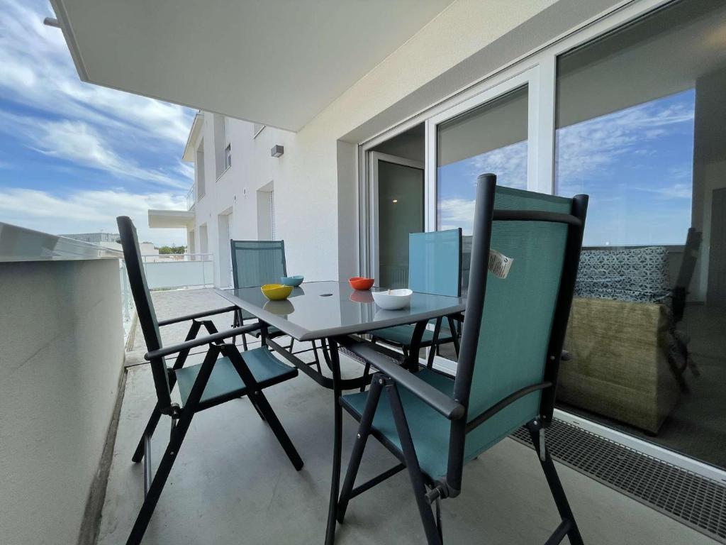 d'une table à manger et de chaises sur un balcon. dans l'établissement Appt 3 pièces LA ROCHELLE - LR670-303, à La Rochelle