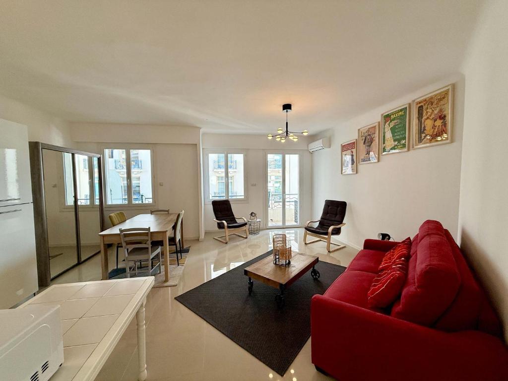 un salon avec un canapé rouge et une table dans l'établissement C083 Croisette - 1 chambre - Vue Epoustouflante, à Cannes