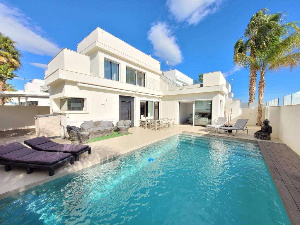 a villa with a swimming pool in front of a house at Casa Spruit in Rojales