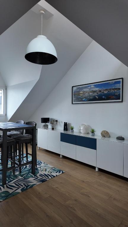 une salle à manger avec une table et une cuisine dans l'établissement **La Bretonnerie, bel appartement de standing, à Concarneau
