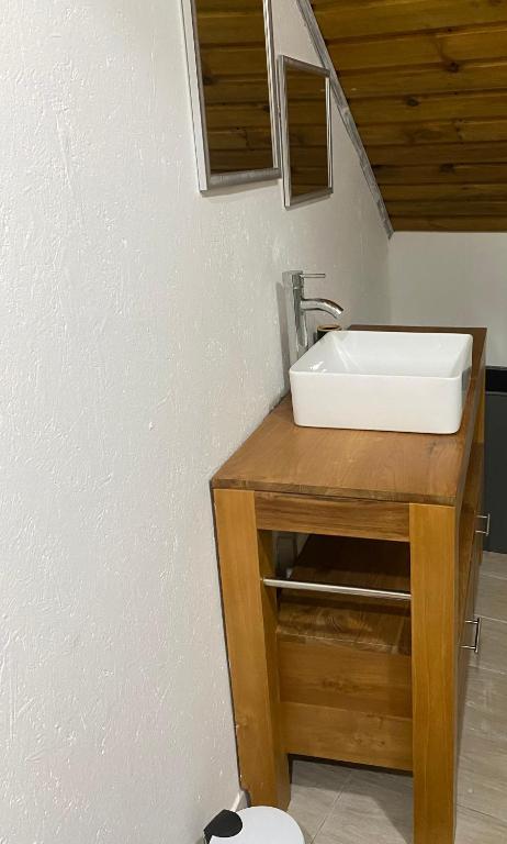 a bathroom with a sink on a wooden counter at Villa bienvenue in Bras des Calumets
