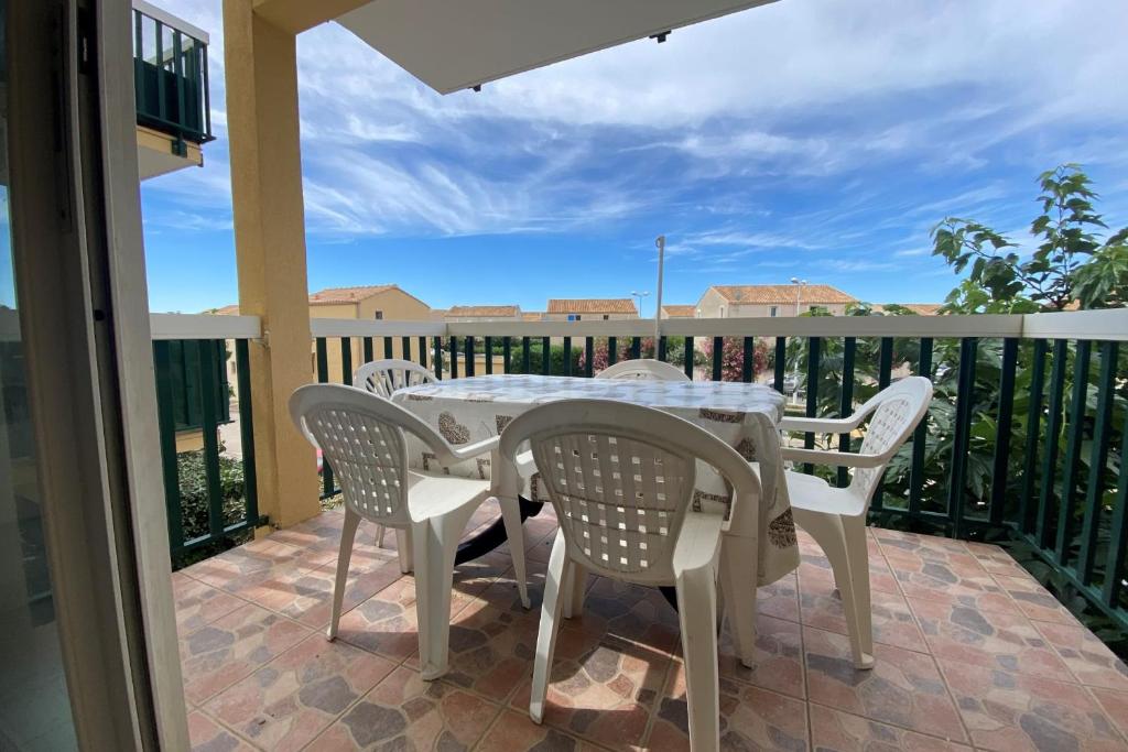 un patio avec une table et des chaises sur un balcon dans l'établissement The echo of the waves, à Frontignan