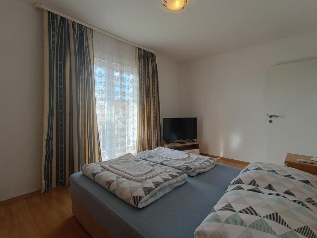 a bedroom with two beds and a large window at Apartmani JT Zadar in Zadar
