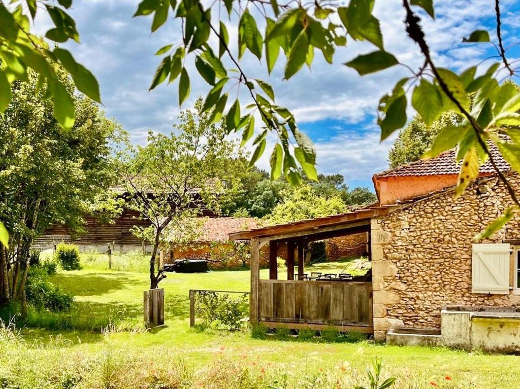 un ancien bâtiment en pierre dans un champ d'herbe dans l'établissement Studio pour 2 - jardin clôturé - grande terrasse couverte, à Capdrot