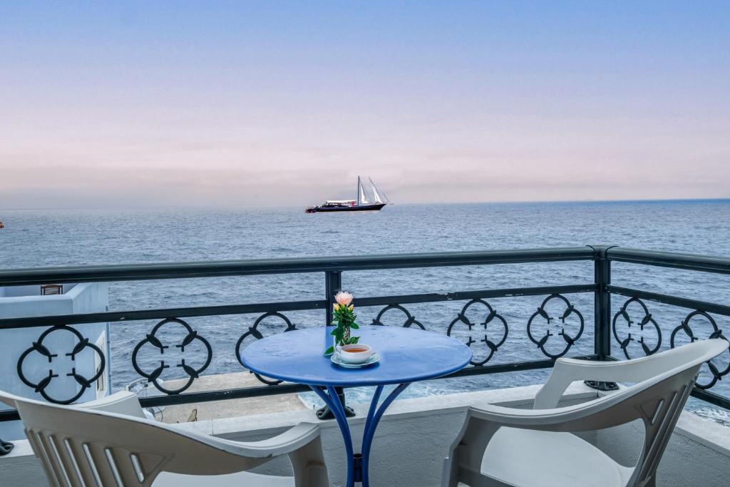 a table on a balcony with a boat in the ocean at Casa del Sol in Kouniádhoi