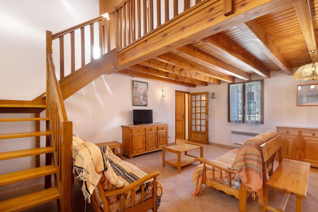 a large room with a staircase and a living room at Maison de village Le Galbe in La Llagonne