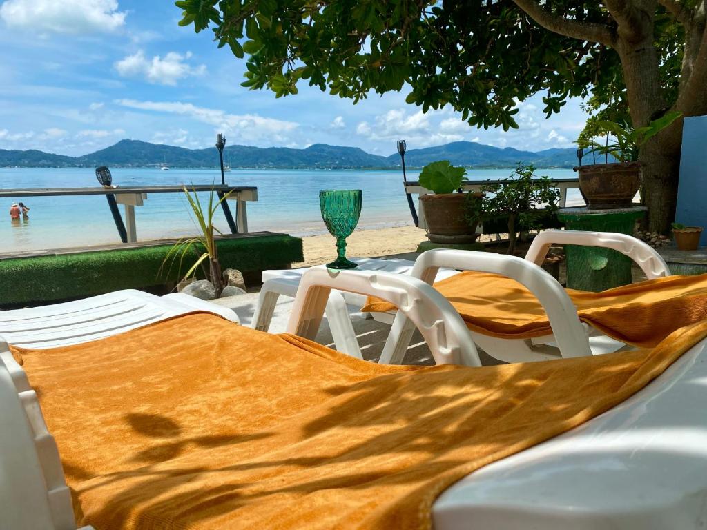 une table et des chaises avec vue sur la plage dans l'établissement Khao Khad Beach Bungalow, à Ko Thanan