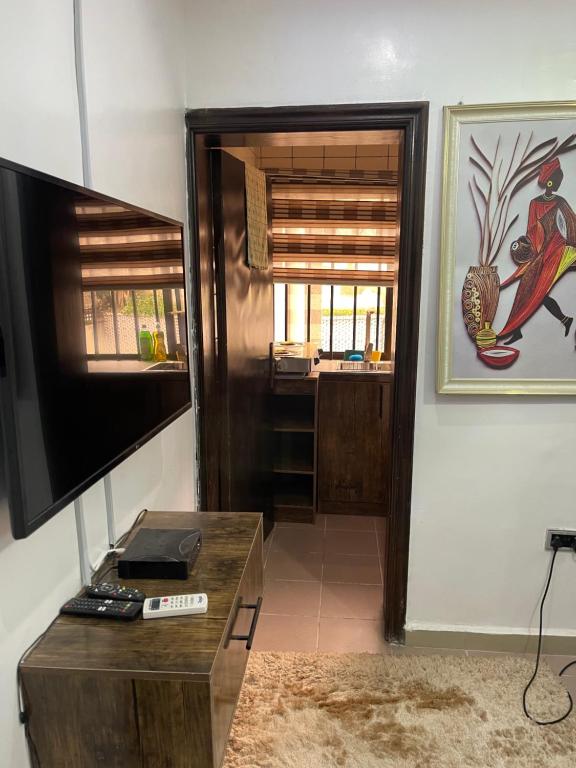 a living room with a flat screen tv and a table at Peridot Studio Apt maitama in Abuja