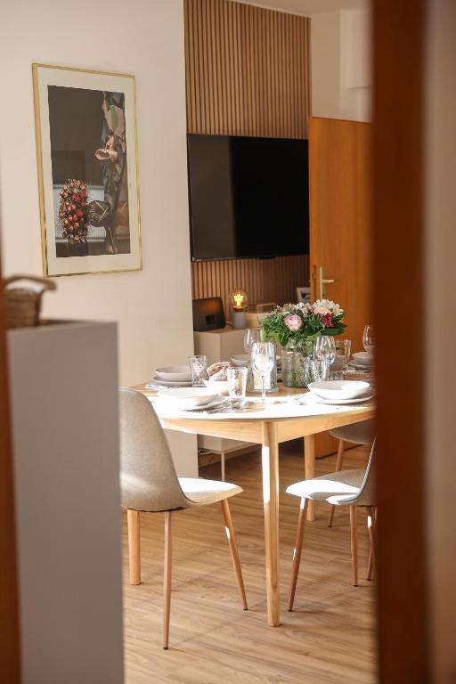 a dining room with a table with chairs and a television at WEINQUARTIER Lindenring 45 qm 2 SZ Altstadt Küche Kaffee in Naumburg