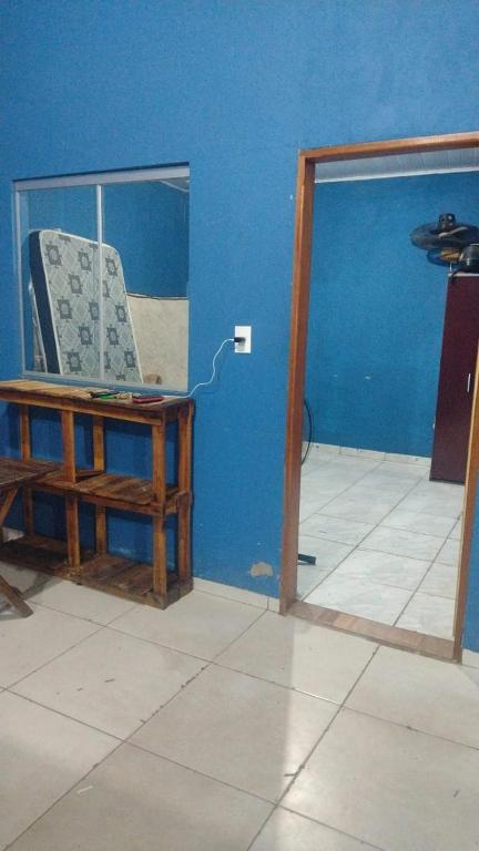 a room with a blue wall with a chair in it at Clube com Piscina in Andradina