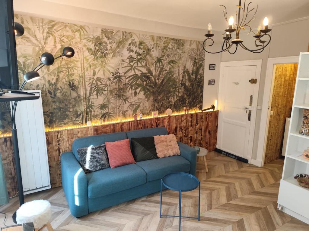 - un salon avec un canapé bleu et un mur dans l'établissement Appartement Place des Eaux Bonnes, à Eaux-Bonnes