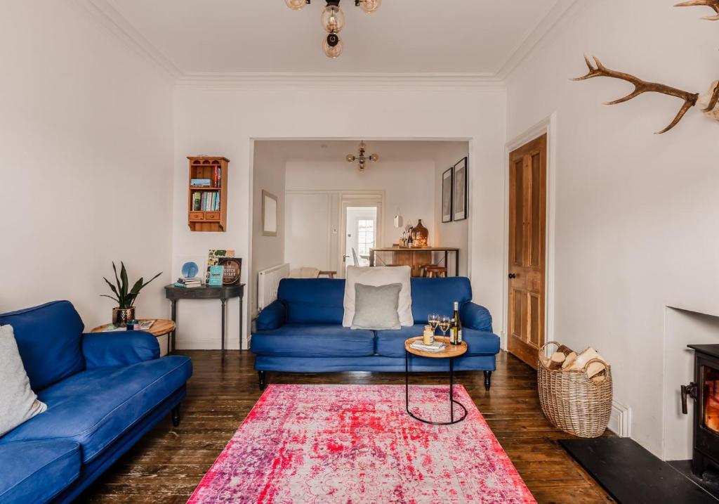 a living room with blue couches and a red rug at Harvieston in Elie