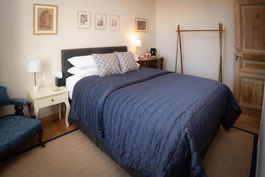 une chambre avec un grand lit avec une couverture bleue dans l'établissement Maison du canal du midi, à Carcassonne