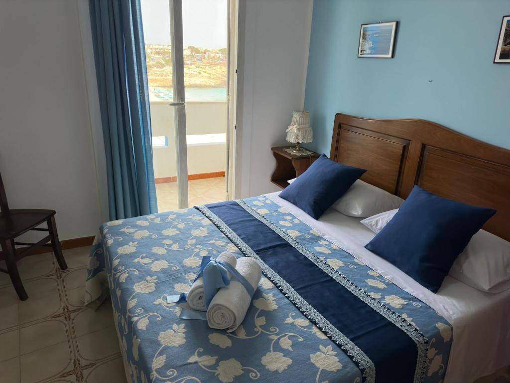 a bedroom with a bed with a stuffed animal on it at Hotel Giglio in Lampedusa